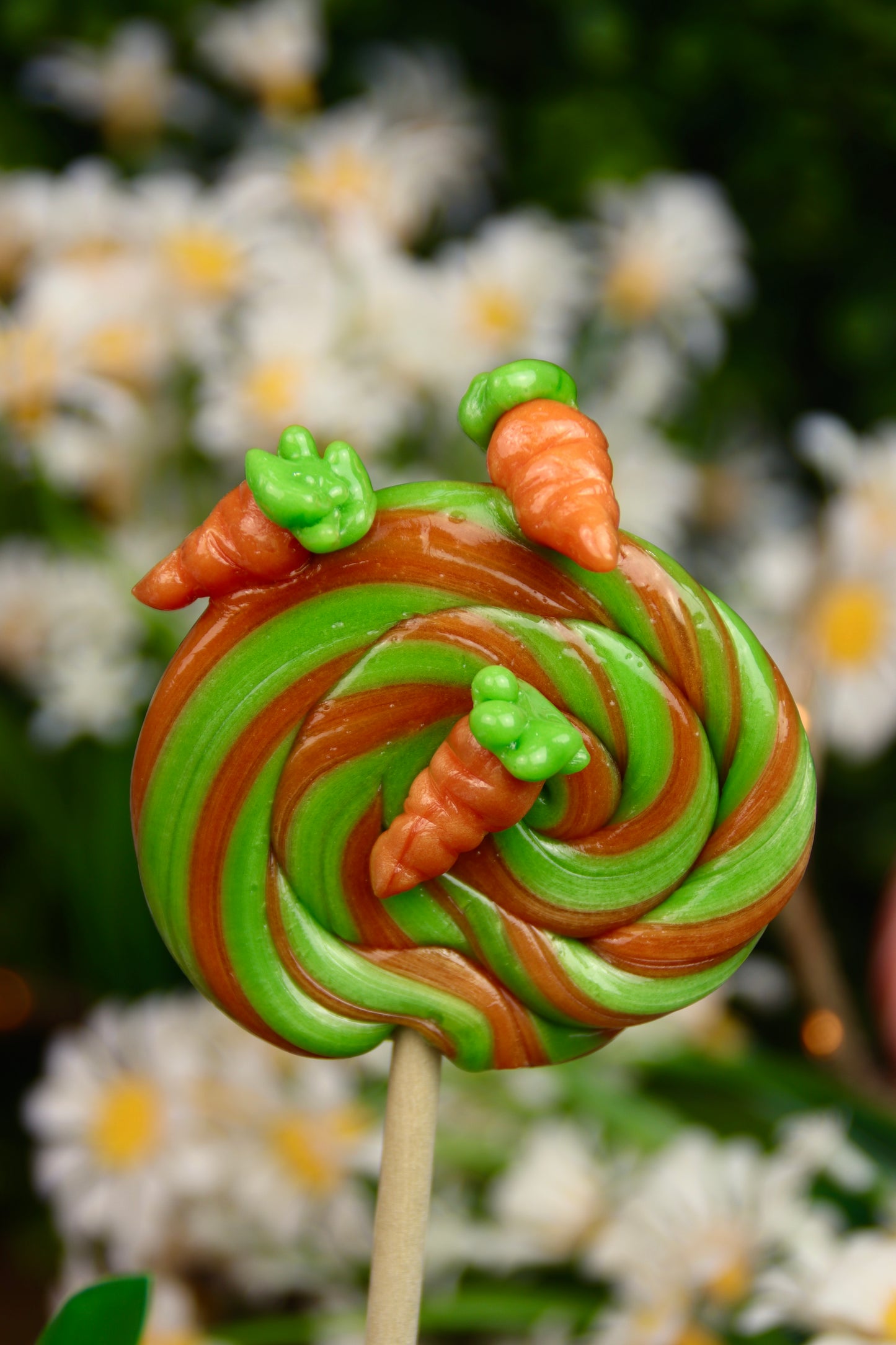 Sucette foraine artisanale en spirale parfumée à la pomme et à l’orange, décorée de petites carottes sculptées à la main. Une gourmandise colorée et ludique, parfaite pour célébrer le printemps