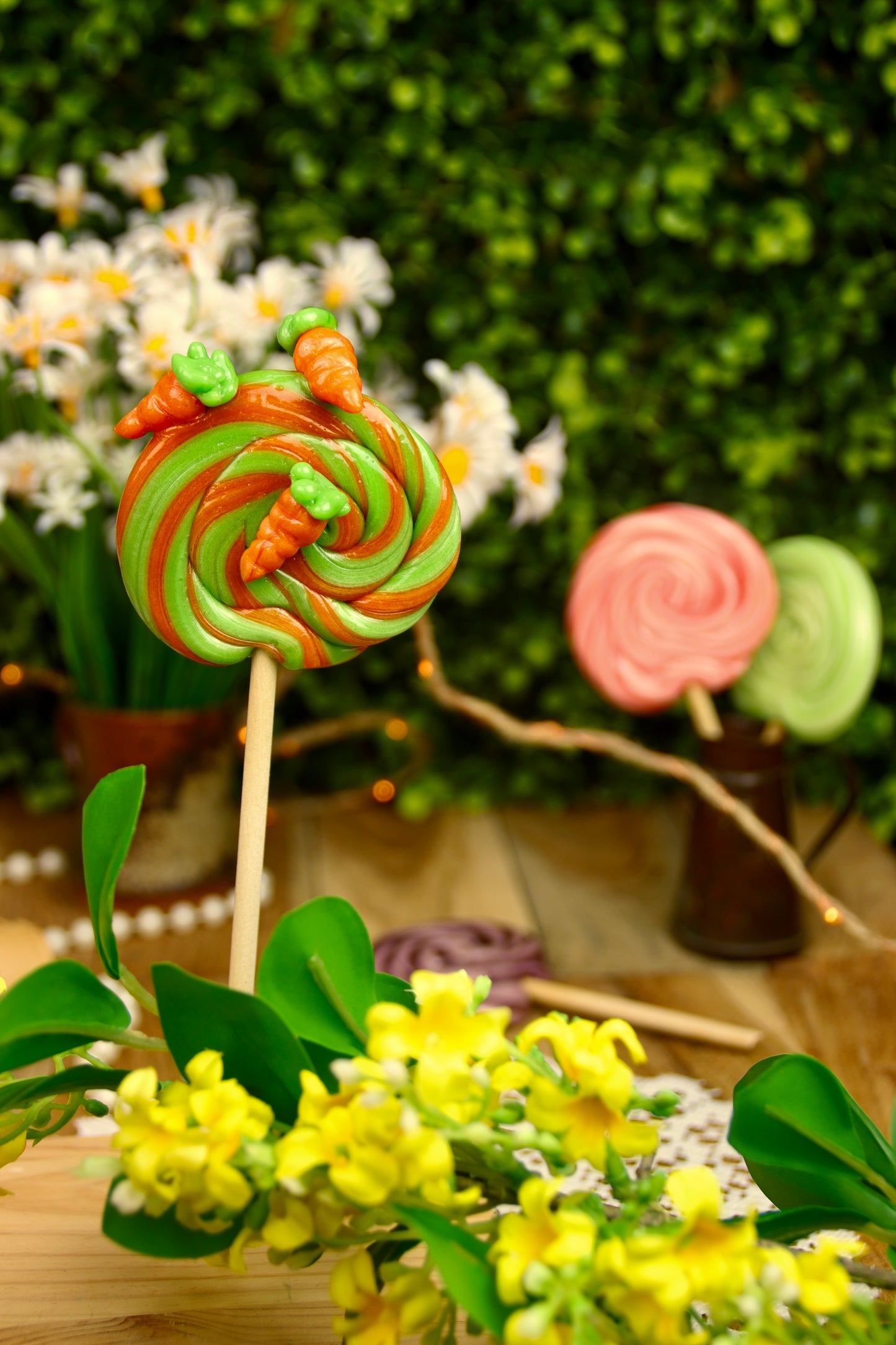 Sucette foraine artisanale en spirale parfumée à la pomme et à l’orange, décorée de petites carottes sculptées à la main. Une gourmandise colorée et ludique, parfaite pour célébrer le printemps