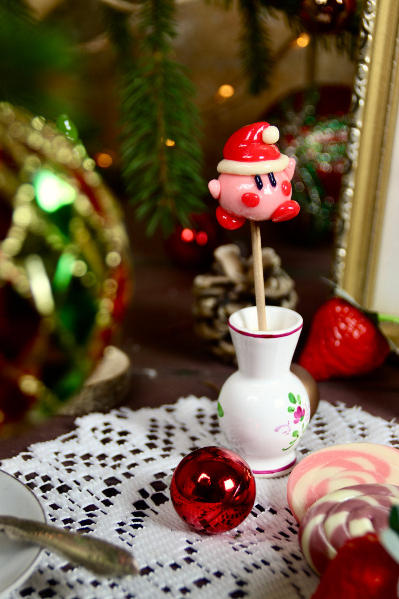 sucette sculptée en forme de Kirby à la fraise dans un décor féérique