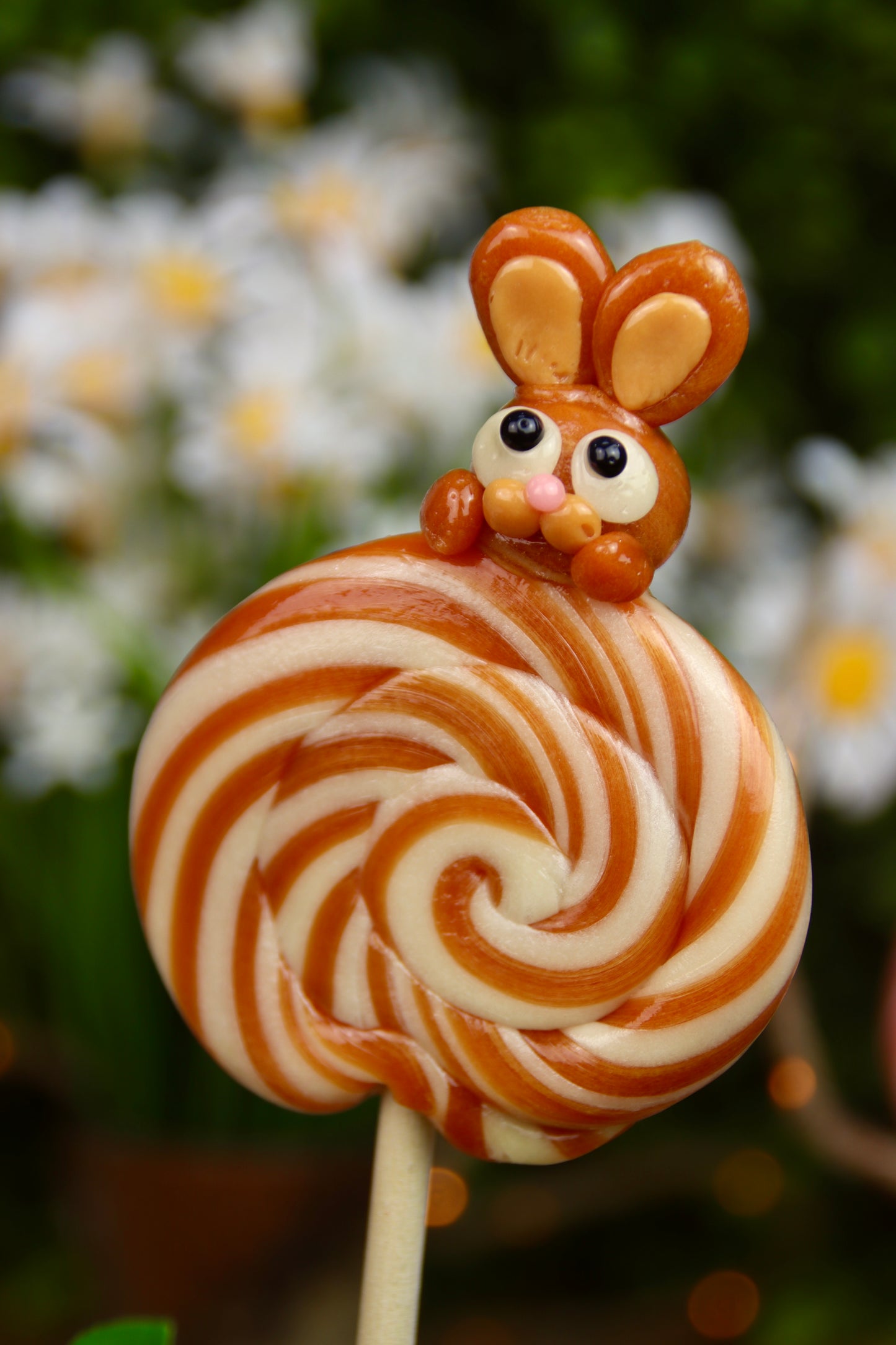 Sucette artisanale en forme de lapin, sculptĂ©e Ă la main, au parfum vanille et caramel beurre salĂ©. Une gourmandise inspirĂ©e des fĂȘtes foraines, prĂ©sentĂ©e sur un bĂąton en bois, avec une finition brillante et dorĂ©e.