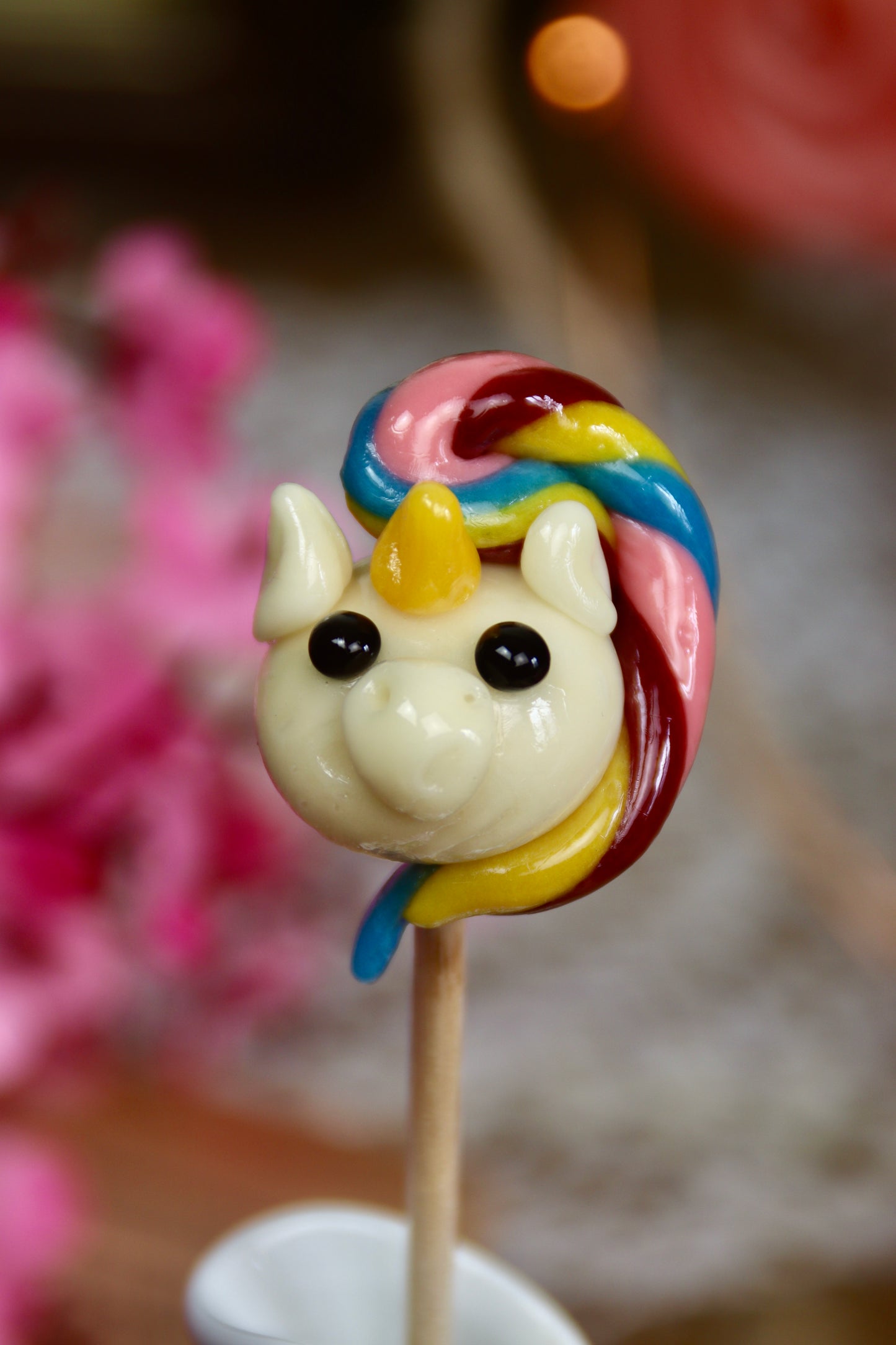 Sucette artisanale en forme de licorne sculptée à la main, crinière arc-en-ciel, parfum multifruit, confiserie colorée fabriquée en France pour anniversaire ou cadeau féerique.