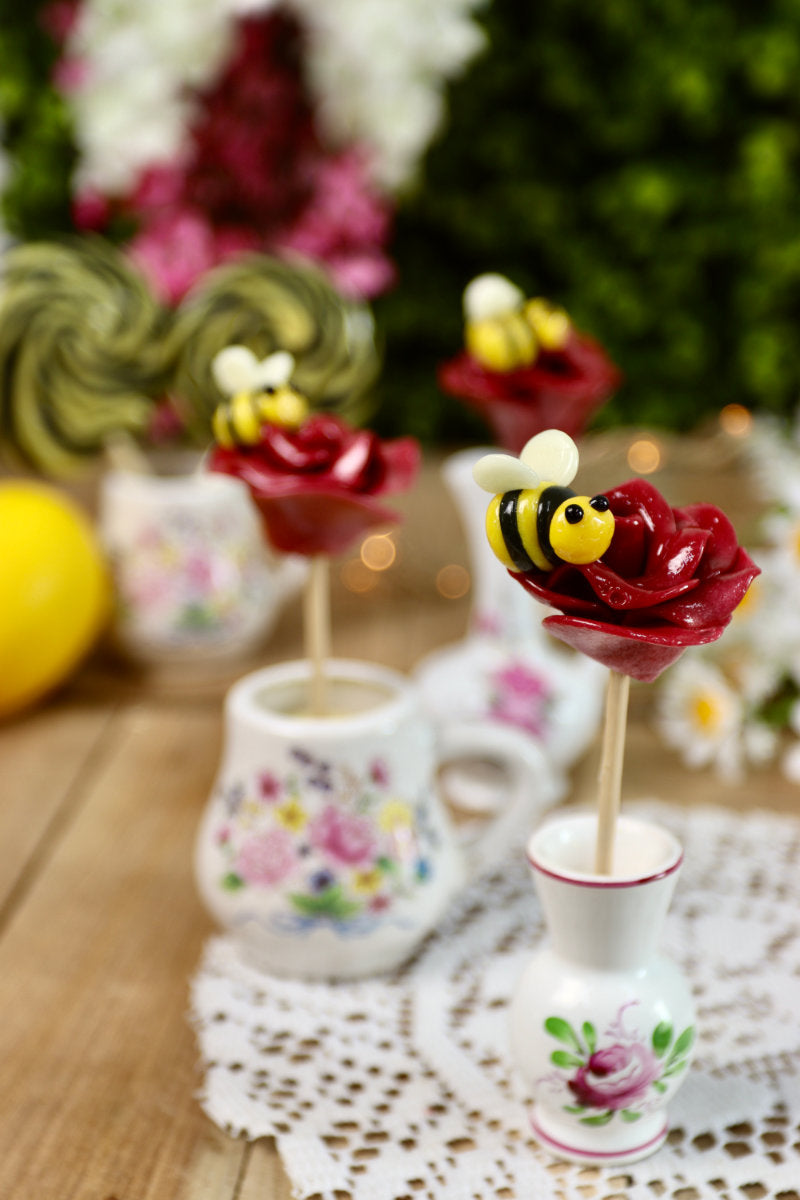 Sucette rose et abeille dans un décor champêtre et fleuri
