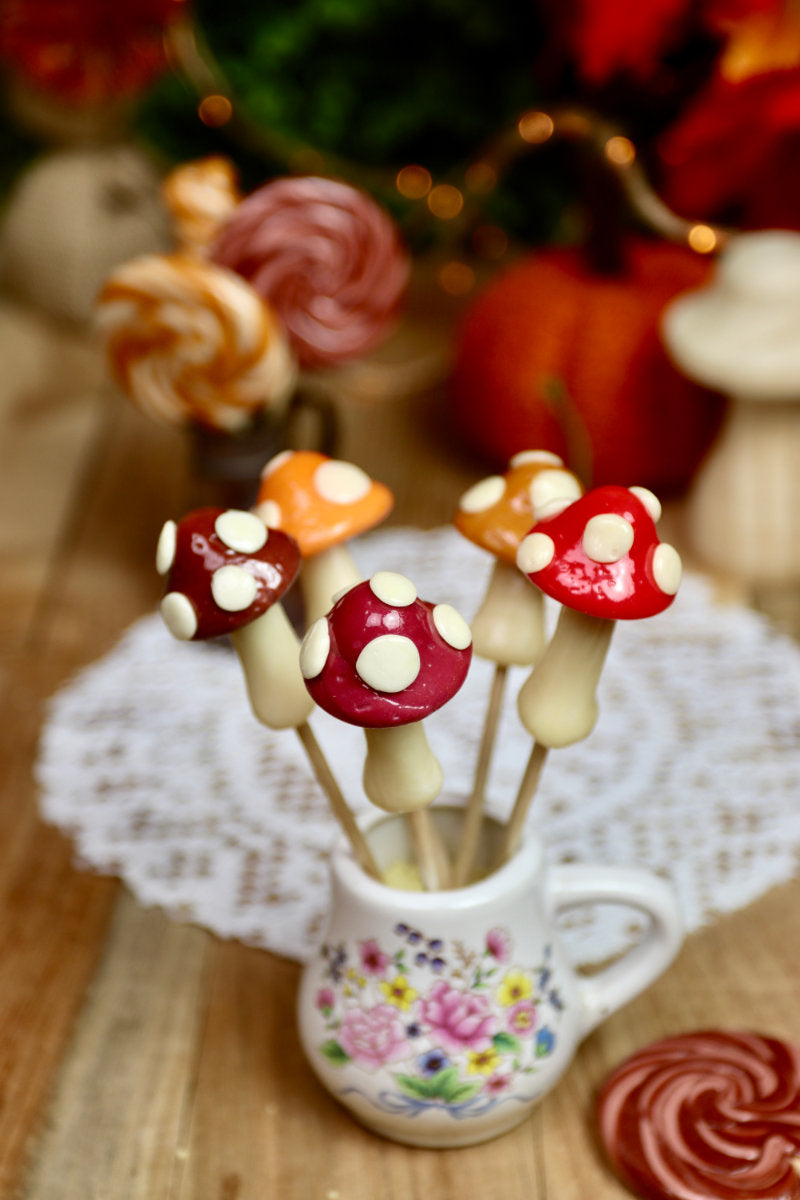 Assortiment de sucettes champignon présenté dans une ambiance automnale féérique