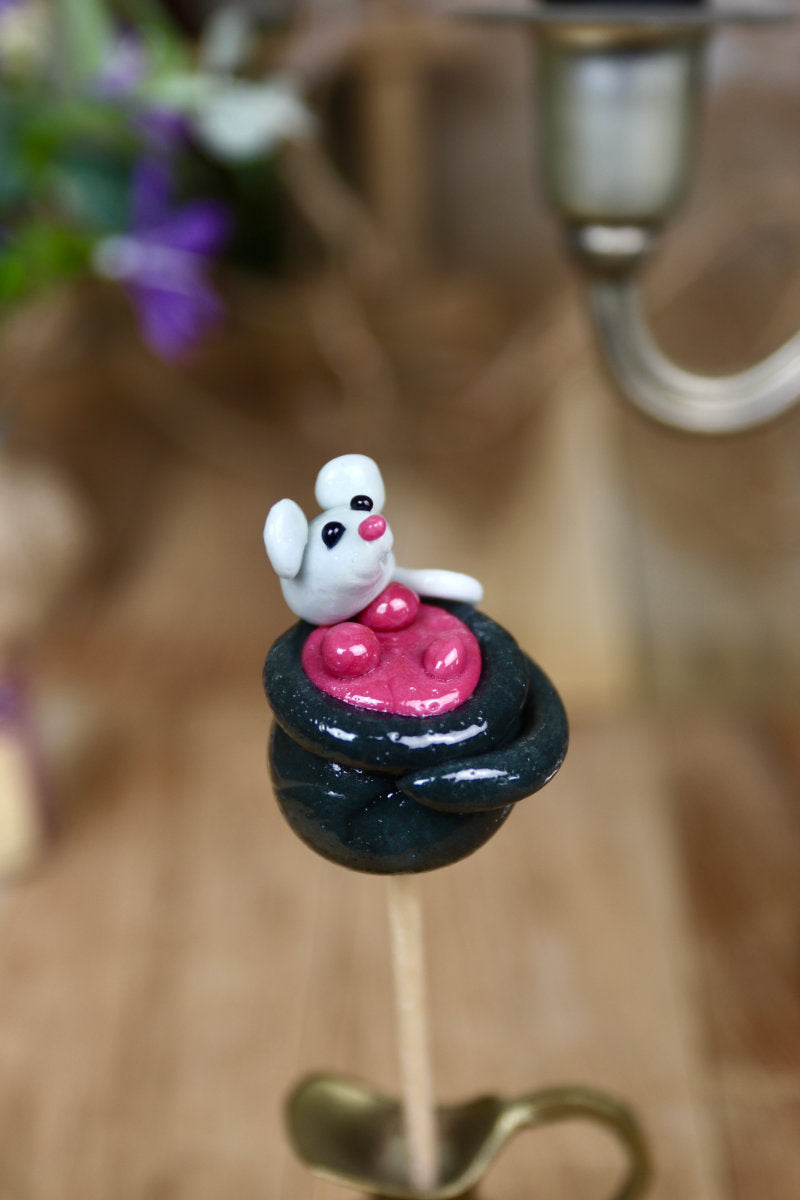 Une sucette en forme de chaudron au cassis avec une petite souris au citron