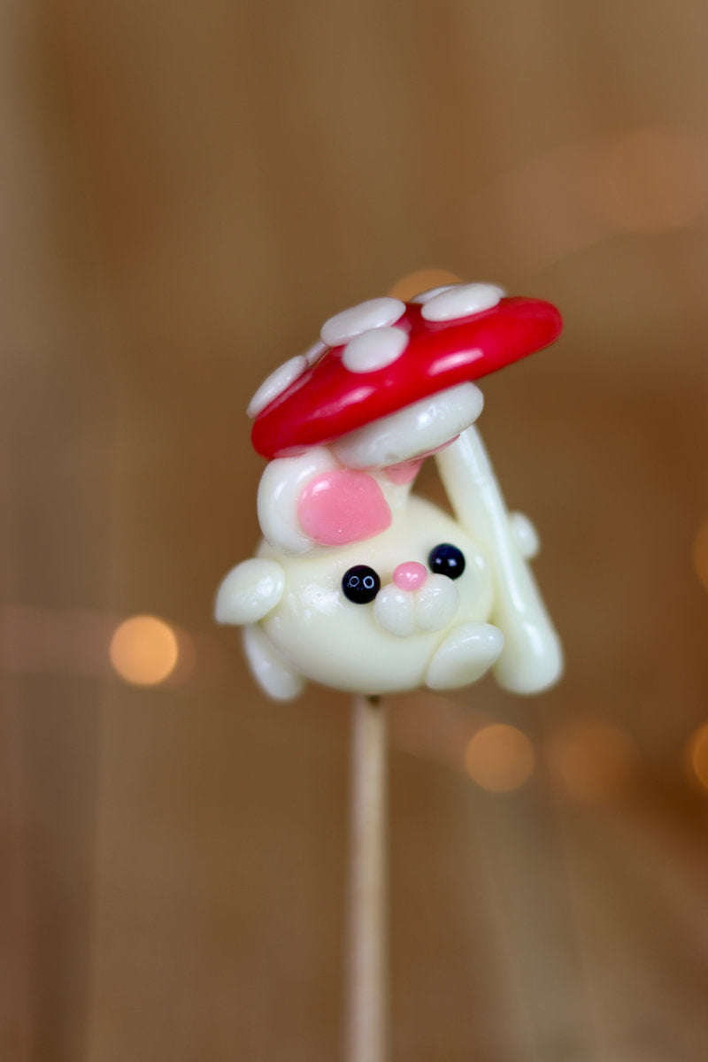 Sucette sculptée en forme de lapin à la banane et tient un parapluie en forme de champignon à la banane et à la framboise