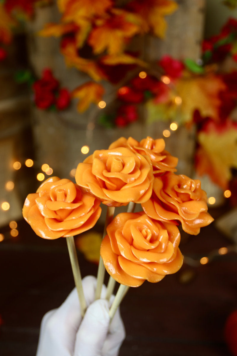 Un bouquet de sucette en forme de fleur à l'orange dans un décor automnale