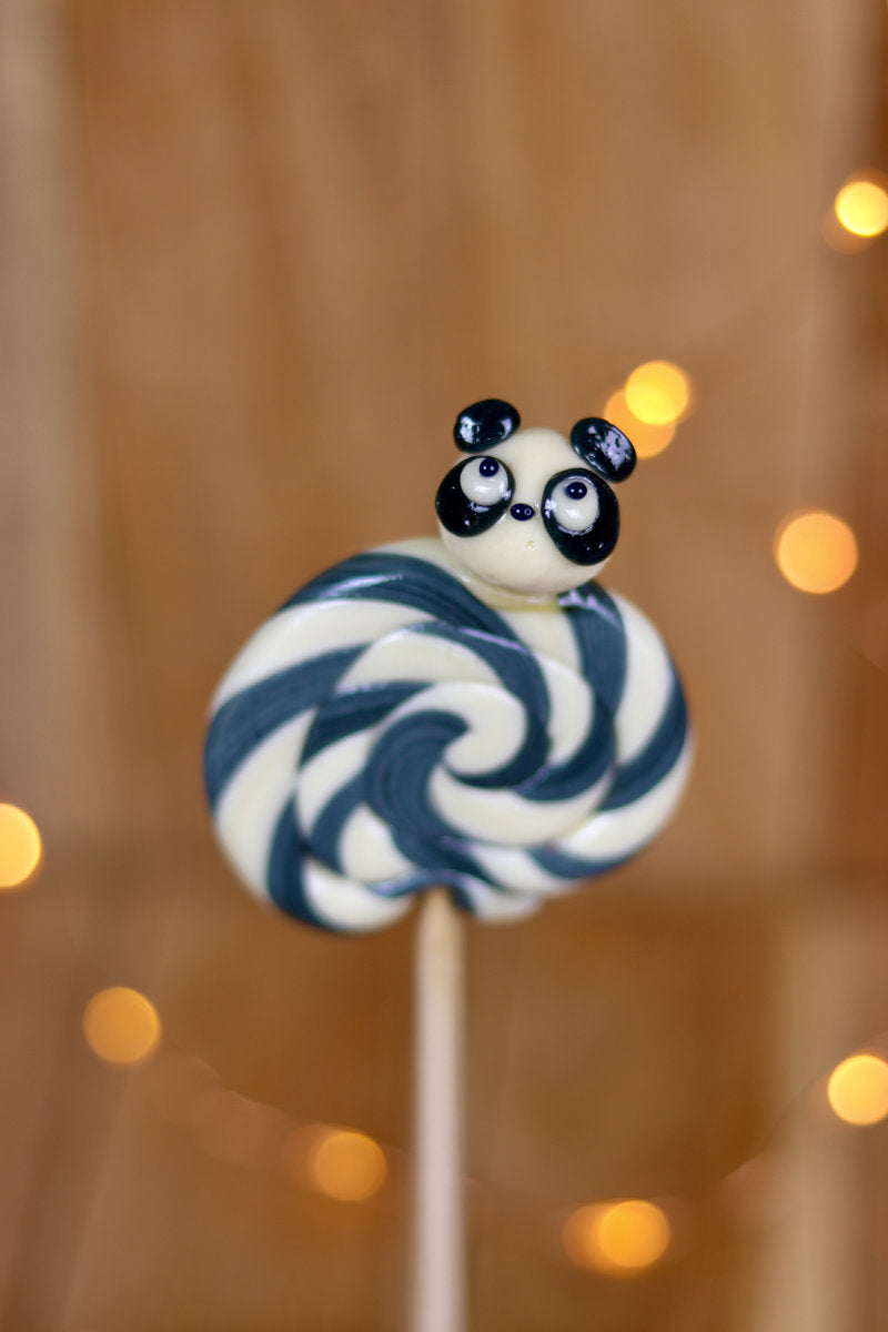 Une sucette foraine artisanale vanille cola avec un panda sculptée dessus