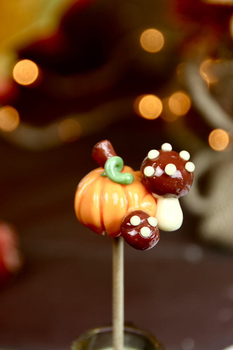 Sucette sculptée citrouille orange aux champignons cacao - Gros plan détaillé artisan français