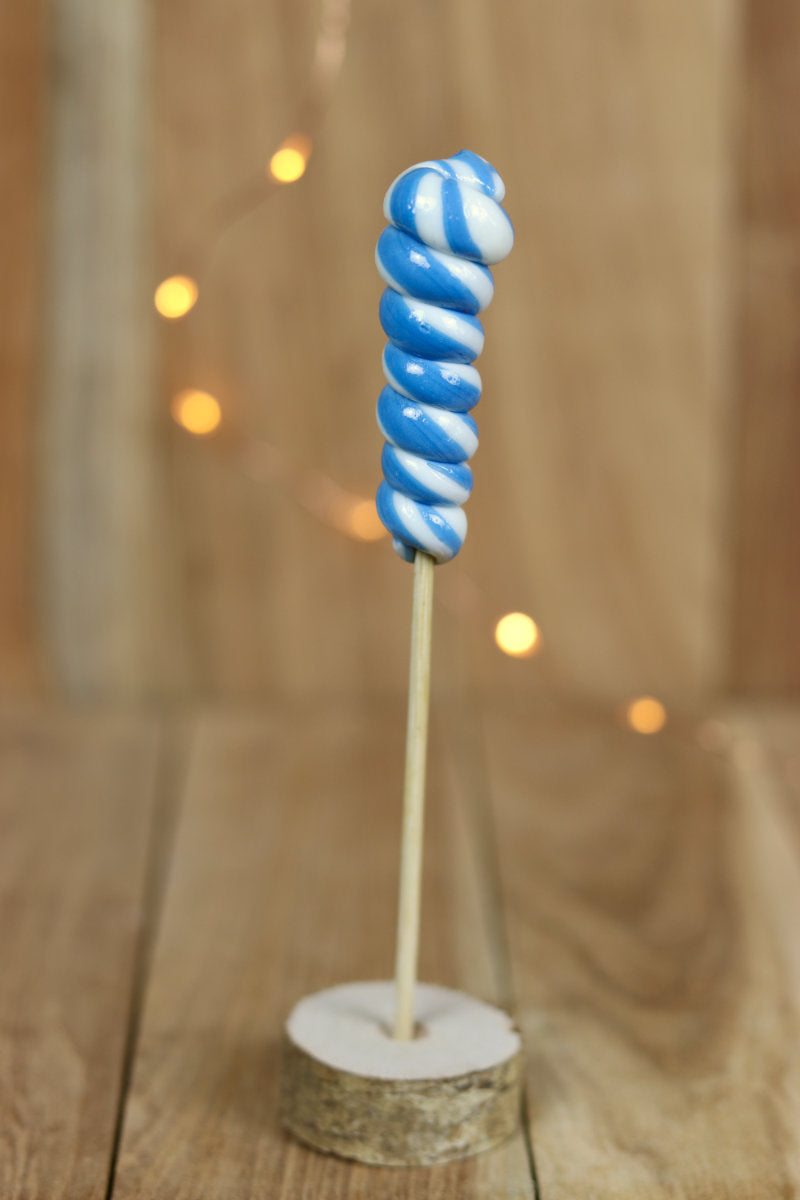 Une sucette torsade fabriqué à la main en sucre cuit aromatisé à la myrtille et au citron. Un tourbillon blanc et bleu