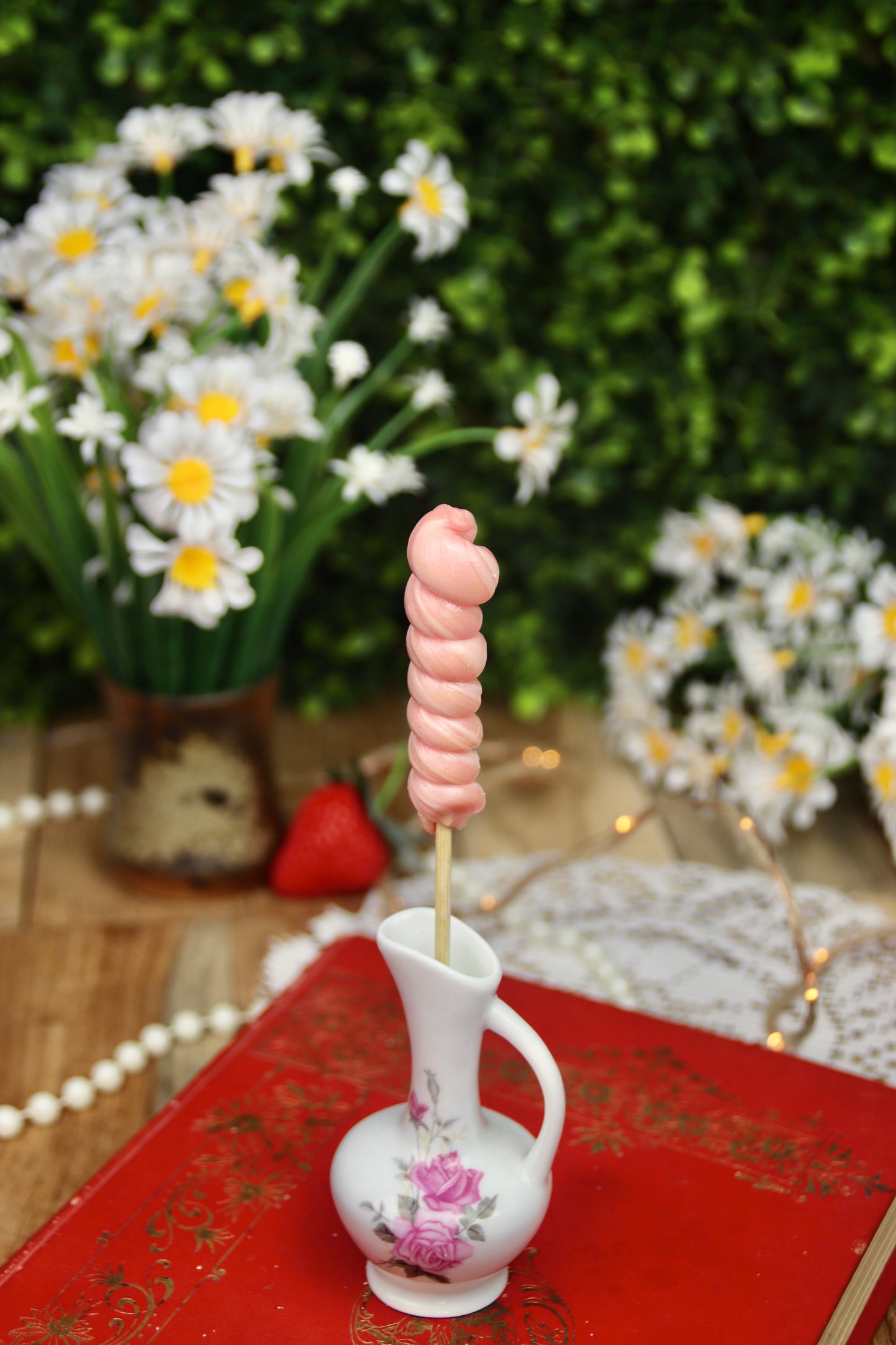 Sucette torsade artisanale parfumée à la fraise, d’un rose pastel délicat. Une gourmandise aux couleurs printanières, fabriquée à la main pour une touche fruitée et sucrée.