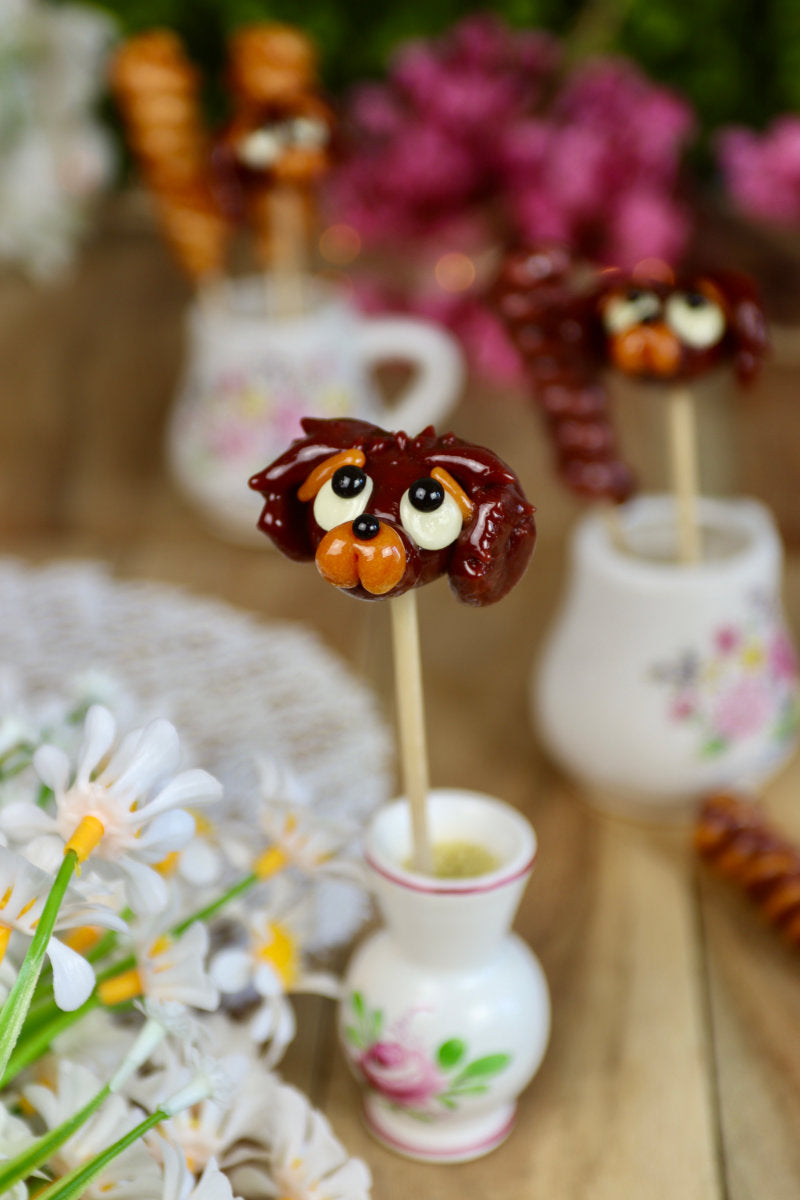 Mise en scène féérique d’une sucette en forme de cocker, idéale pour offrir ou décorer une table gourmande