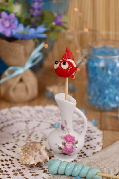 Sucette poisson framboise noix de coco dans un décor marin, entourée de coquillages et d’éléments océaniques, idéale pour une ambiance gourmande et féérique.