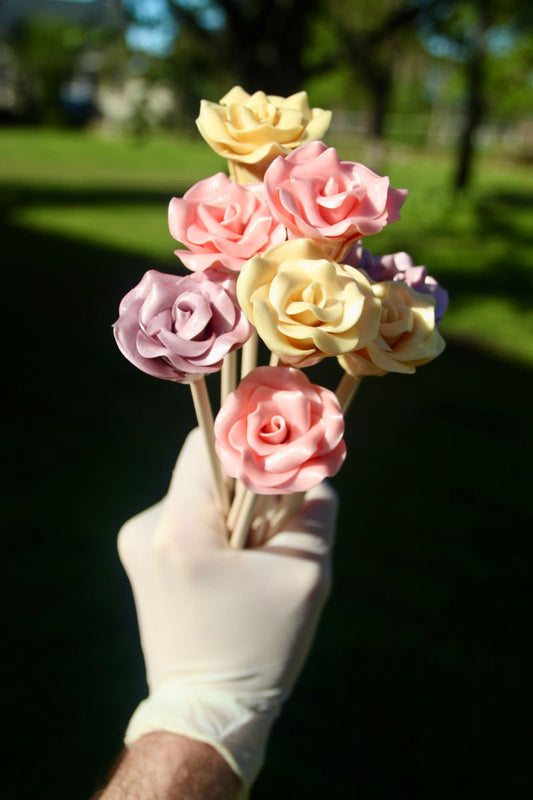 Un bouquet de sucette en forme de fleur comestible dans des couleurs printanières. Photo prise dans un jardin 