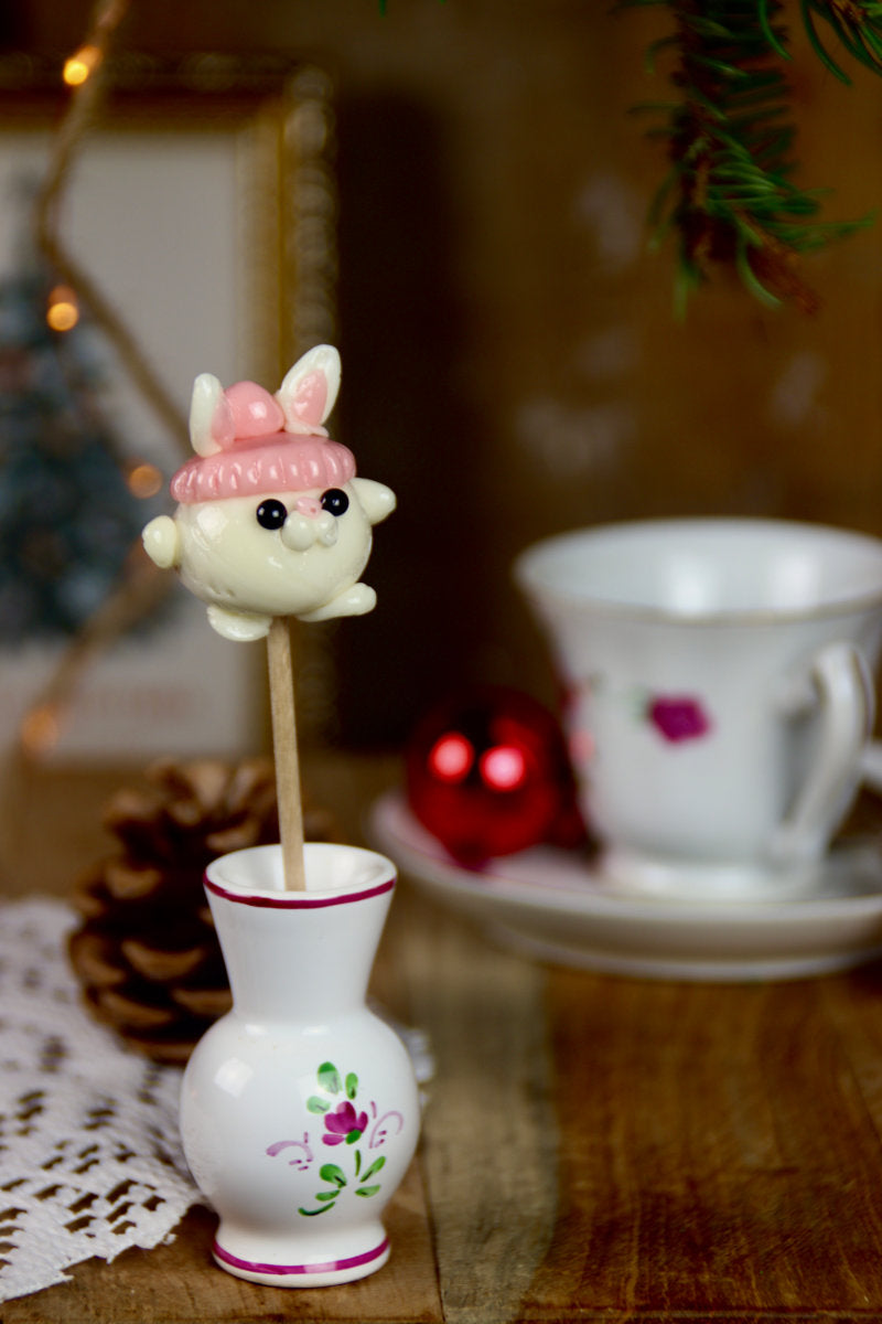 Sucette sculptée en forme de lapin portant un bonnet 