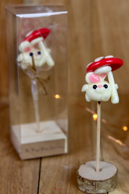 Sucette sculptée en forme de lapin à la banane et tient un parapluie en forme de champignon à la banane et à la framboise