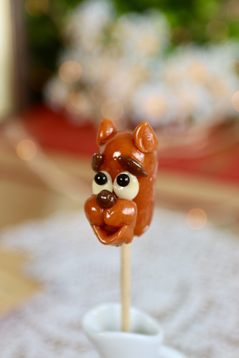 Sucette artisanale en forme de chien sculpté, au parfum cola, vue en détail