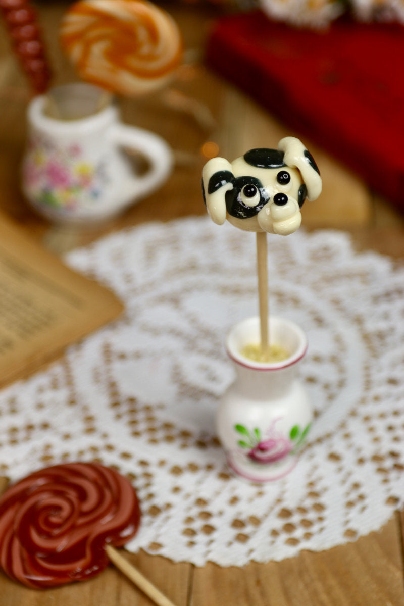 Sucette dalmatien posée dans une ambiance enfantine ou joyeuse, entourée d’accessoires évoquant les chiots ou les dessins animés.