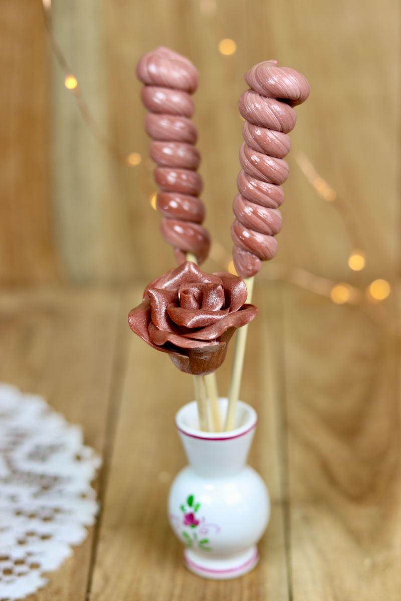 Un bouquet de sucette au cacao. Des sucettes torsade et une sucette sculptée en forme de rose