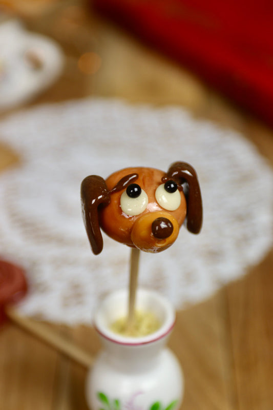Sucette artisanale en forme de teckel, sculptée à la main dans des tons caramel et cola