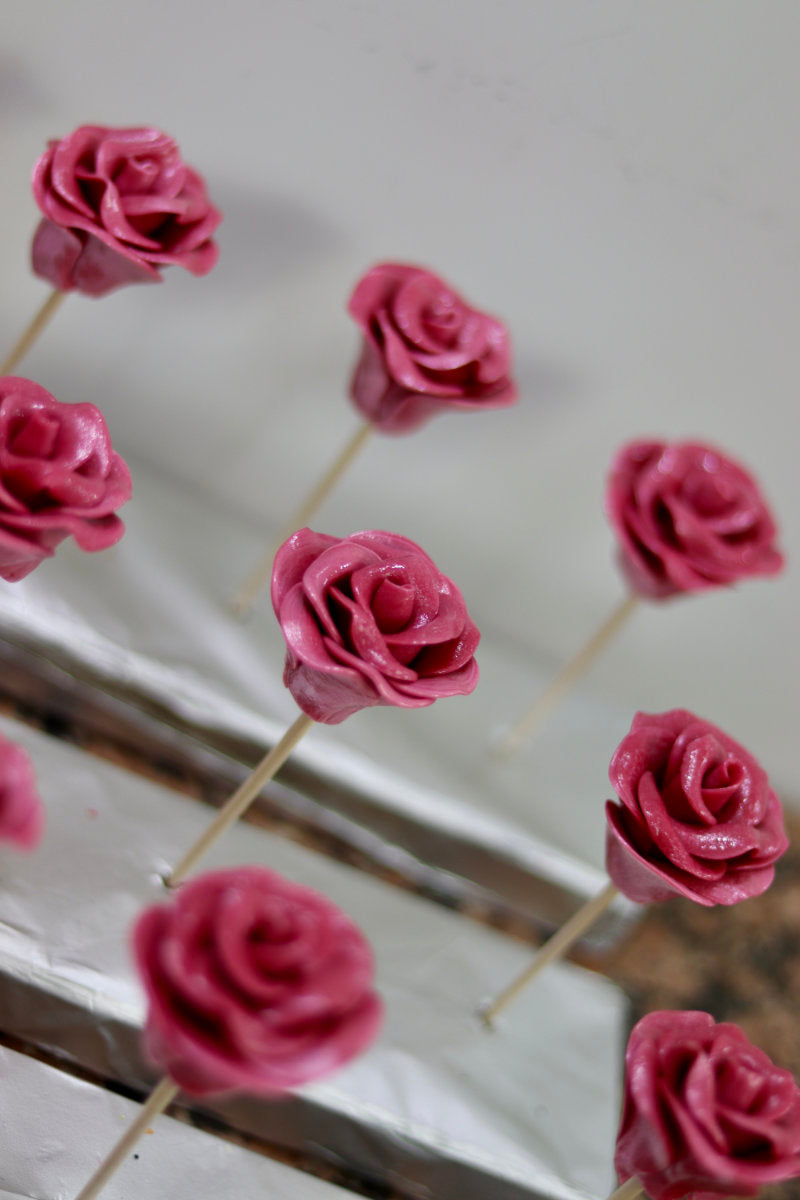 Sucette sculptée en forme de rose à la cerise dans un atelier francais