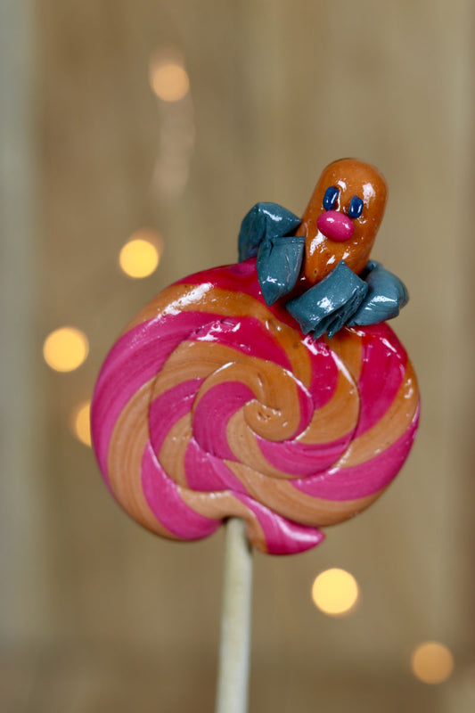 Une sucette foraine artisanale au cola et à la cerise ave un Pokémon Taupiqueur sculptée dessus.