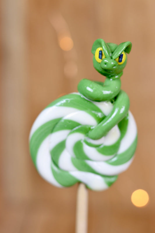 Une sucette foraine artisanale au citron et à la pomme avec un serpent sculptée en sucre cuit à la pomme dessus. 