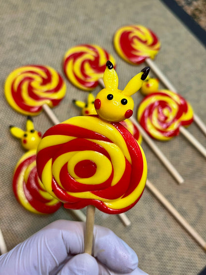 Sucette foraine banane cerise avec un pikachu sculptée à la banane dessus dans l'atelier de production