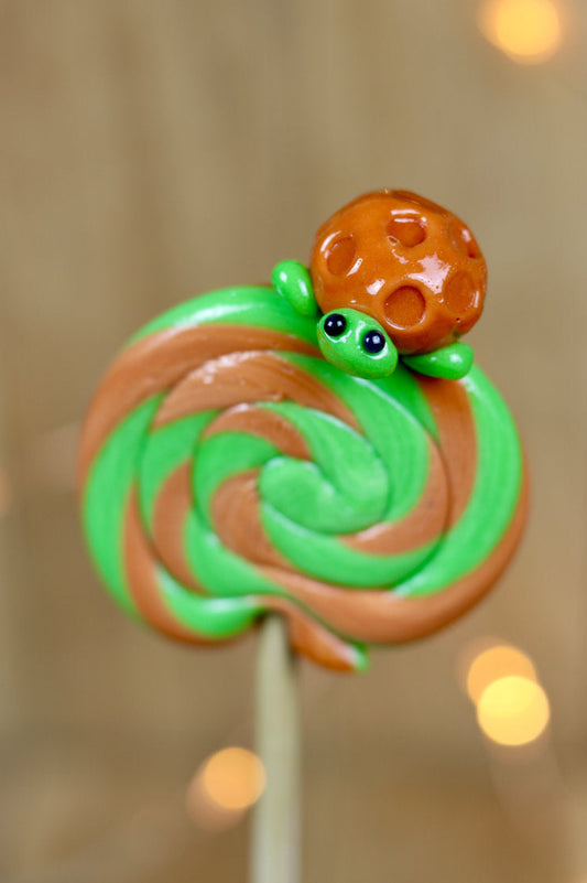 Sucette foraine artisanale pomme caramel, avec une tortue sculptée dessus