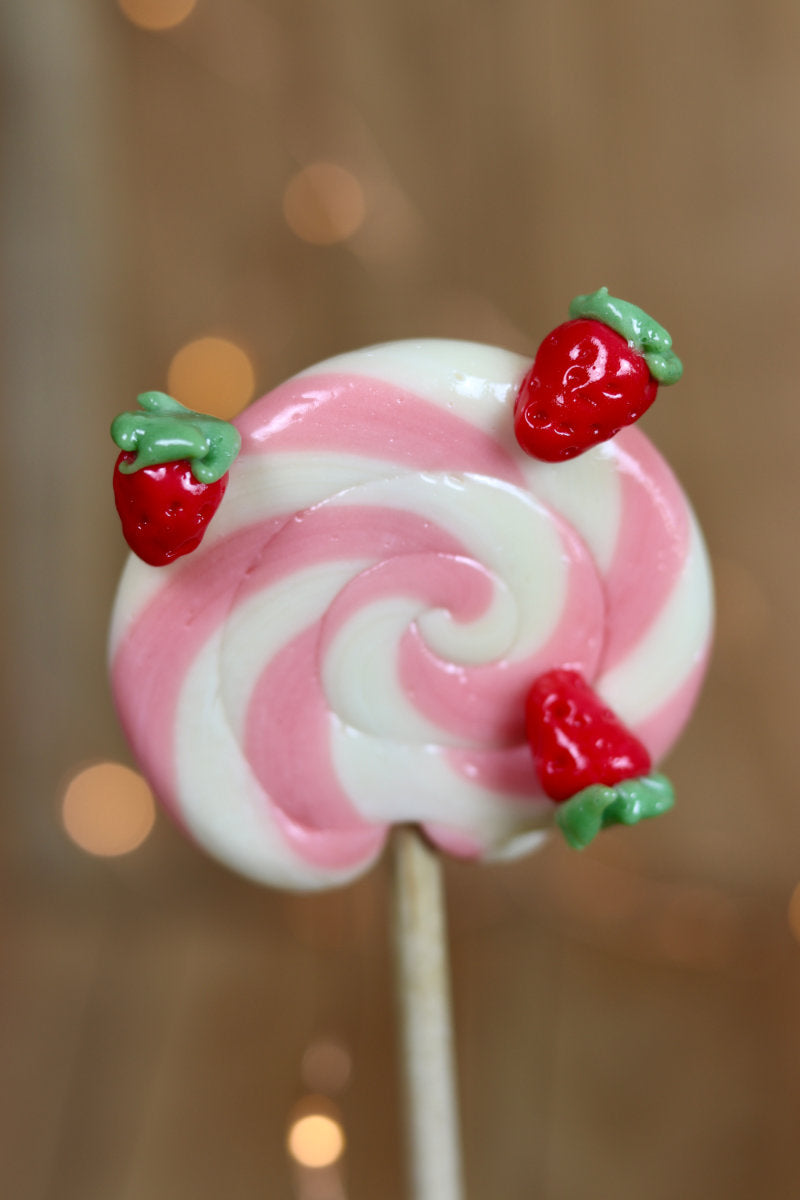 Une sucette foraine vanille fraise avec des petites fraises sculptées 