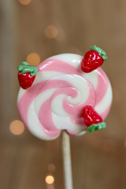 Une sucette foraine vanille fraise avec des petites fraises sculptées 