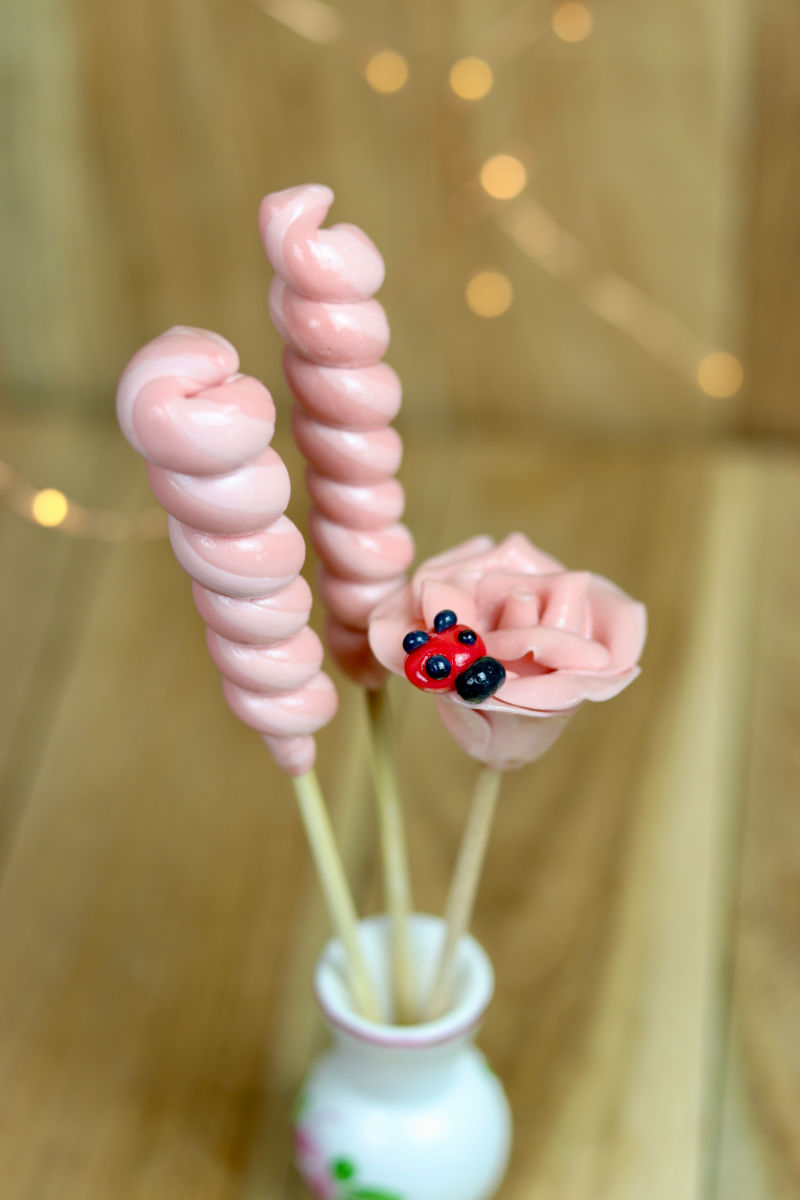 Bouquet de sucette à la framboise avec deux torsades et une sucette sculptée en forme de rose avec une coccinelle