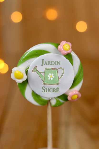 Sucette imprimée au centre : jardin sucré. Avec le dessin d'un arrosoir. Quelques fleurs sculptées. Pomme citron