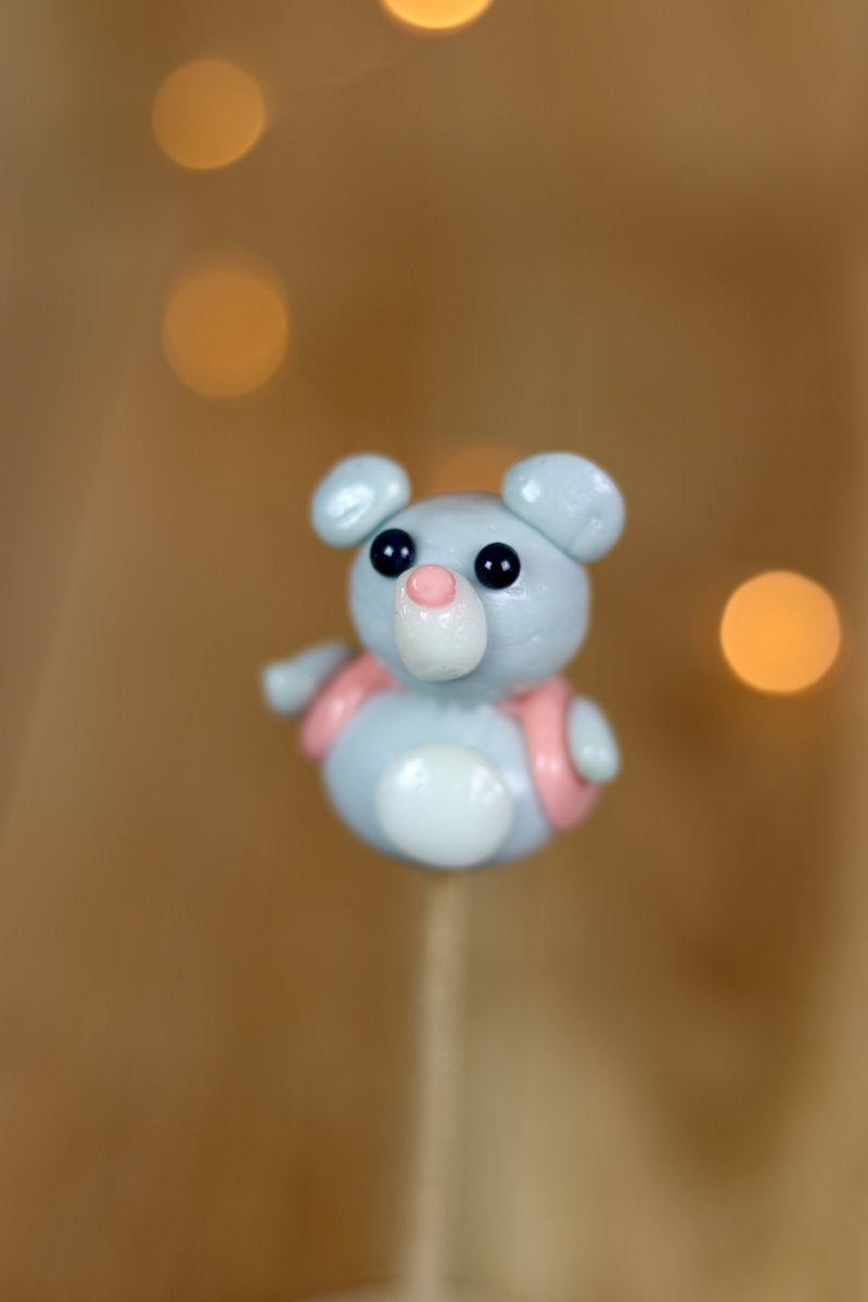 Une sucette sculptée en forme de souris qui porte un petit gilet. Au citron et à la framboise