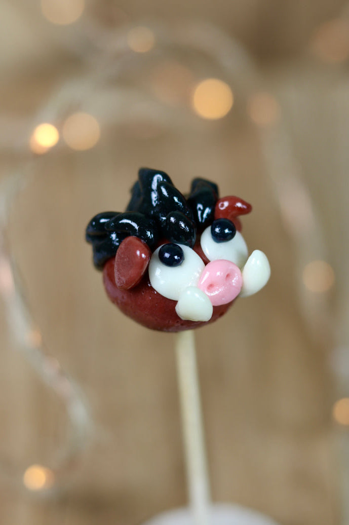 Sucette sculptée en forme de sanglier au cacao et au fruit rouge