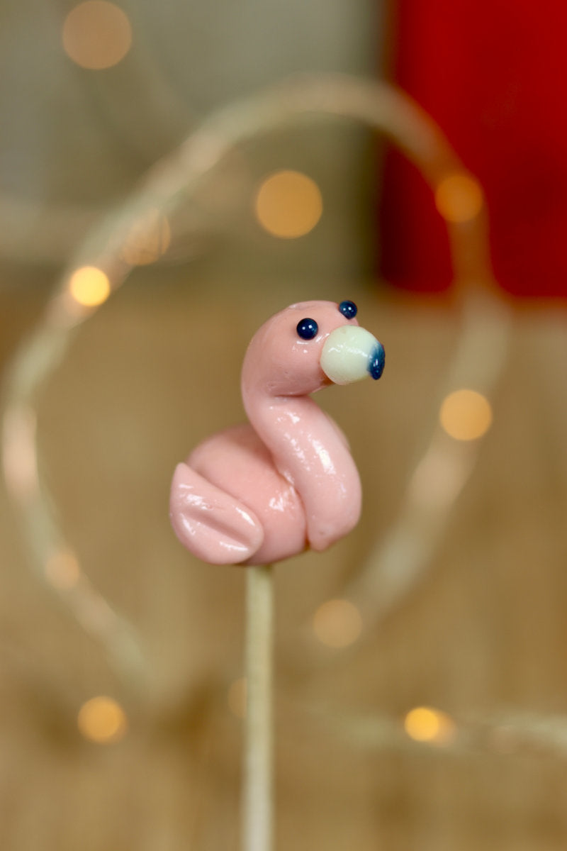 Une sucette artisanale sculptée à la main en forme de flamant rose à la framboise