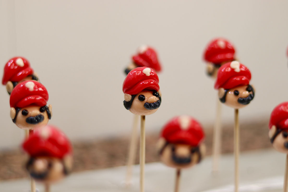 Sucette sculptée en forme de Mario à la banane et à la cerise dans l'atelier de production en Bourgogne
