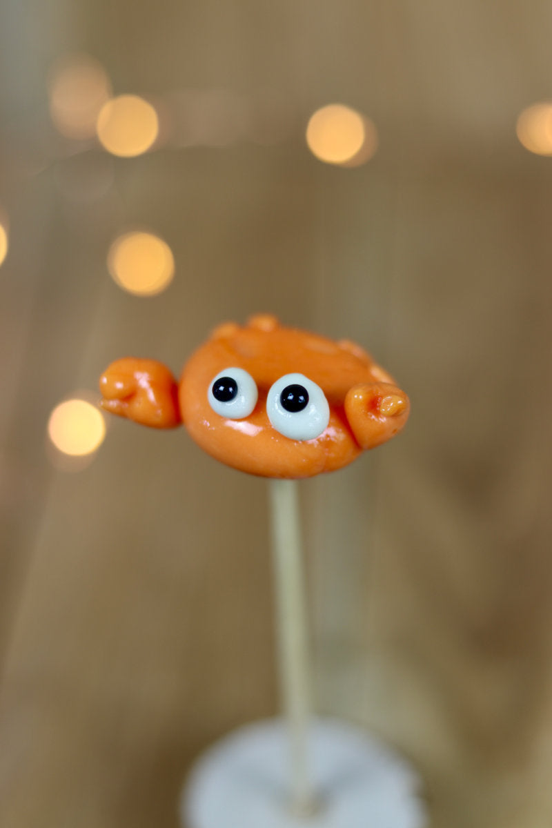 Une sucette sculptée à la main en forme de crabe, elle est réalisé en sucre cuit au melon. 