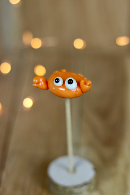 Une sucette sculptée à la main en forme de crabe, elle est réalisé en sucre cuit au melon. 