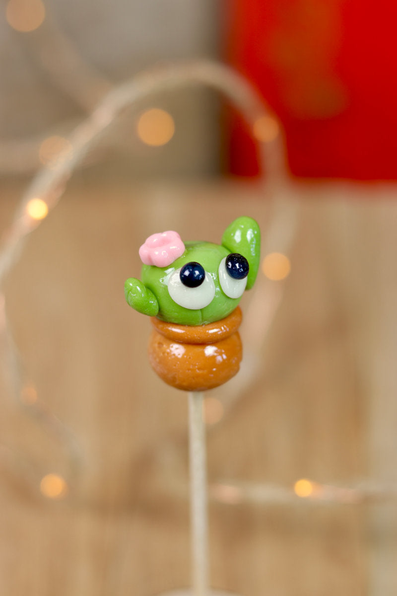 Sucette sculptée en forme de cactus dans un pot de fleur, à la pomme et au caramel 