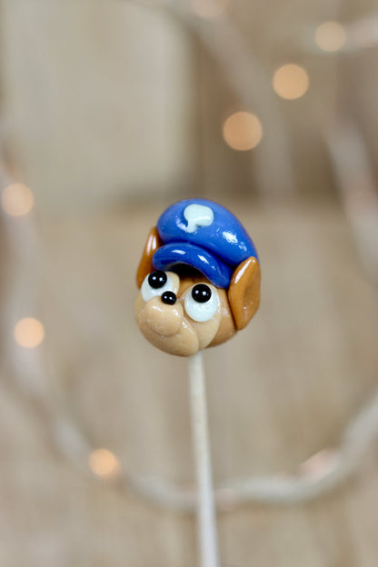 Sucette sculptée en forme de Chase de la Pat'Patrouille, au caramel et à la myrtille