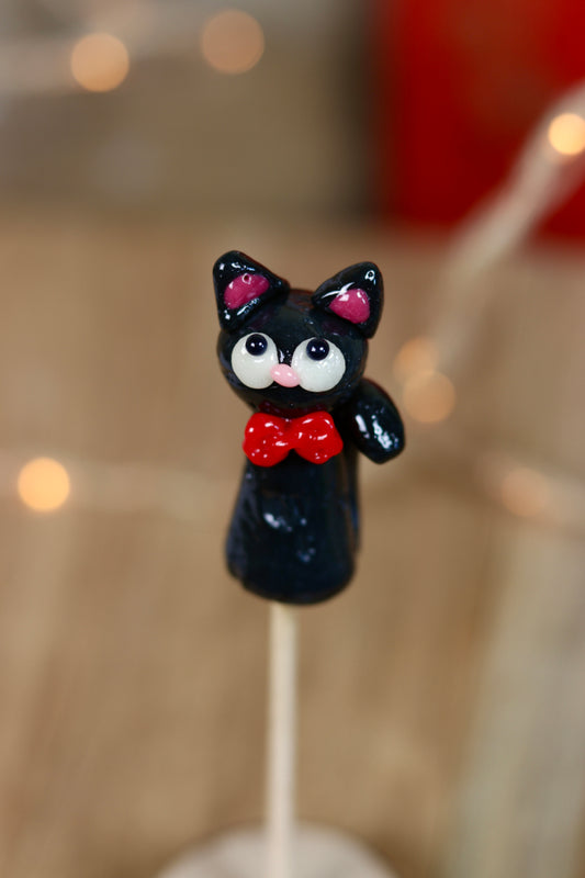 Sucette en forme de chat noir au cassis avec un noeud rouge au cou