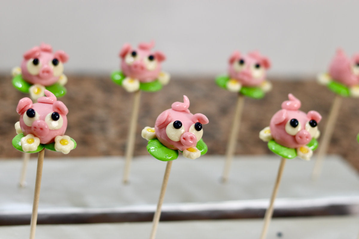 Sucette sculptée en forme de cochon à la fraise dans une prairie à la pomme dans l'atelier de fabrication