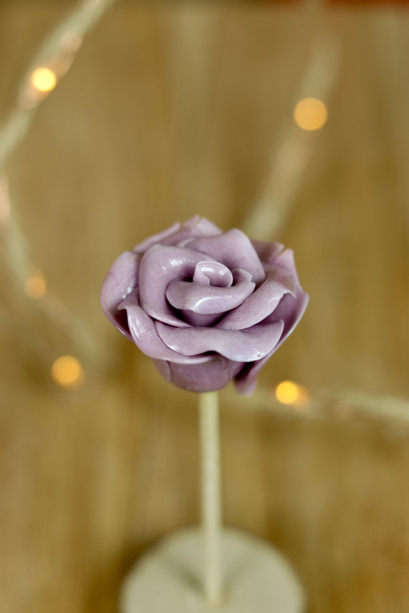 Sucette artisanale sculptée en de rose à la violette en sucre cuit. 