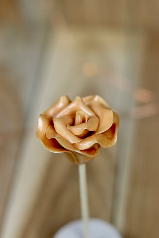 Une sucette sculptée en forme de fleur au spéculoos en sucre cuit