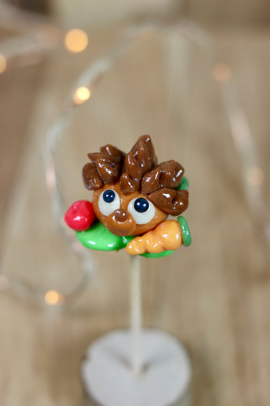 Sucette sculptée en forme de hérisson au millieu d'un potager multifruit