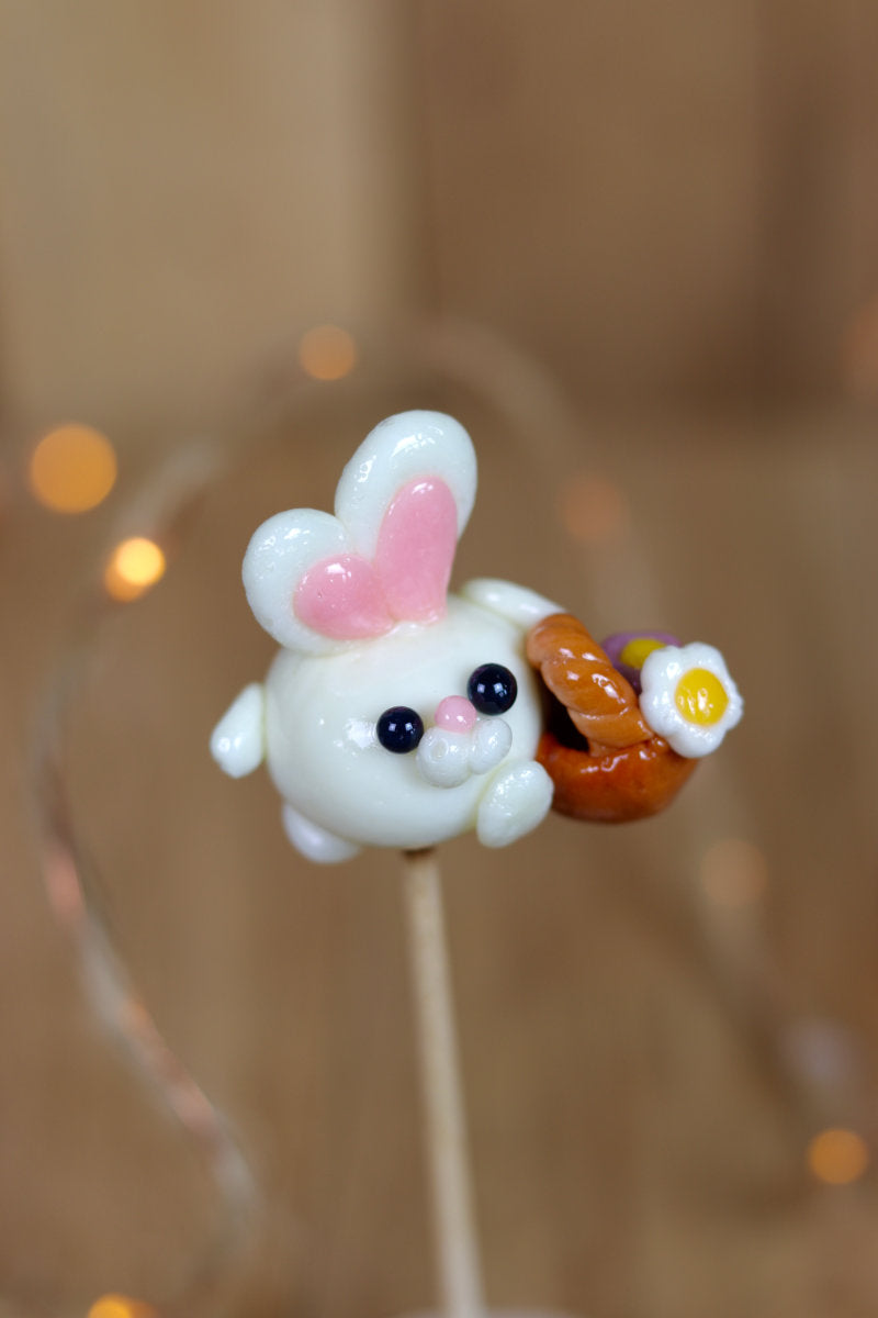 Sucette sculptée en forme de lapin à la banane qui porte un panier de fleur