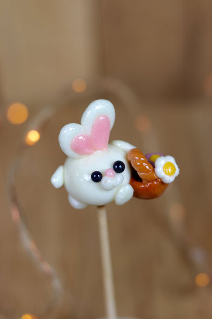 Sucette sculptée en forme de lapin à la banane qui porte un panier de fleur