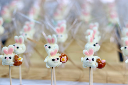 Sucette sculptée en forme de lapin à la banane qui porte un panier de fleur dans l'atelier de fabrication