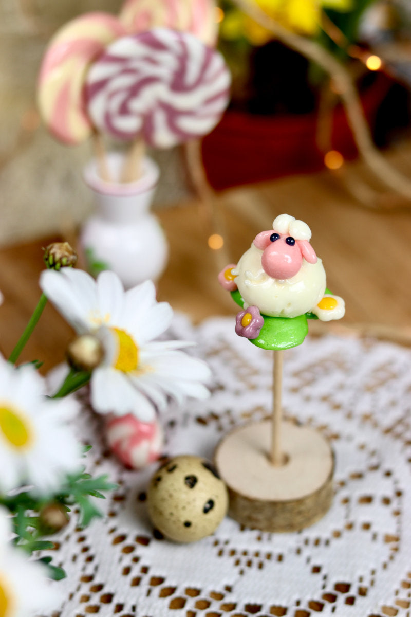 Sucette sculptée en forme de mouton à la banane et à la fraise dans une prairie fleurie multifruit. Dans un déco printanier