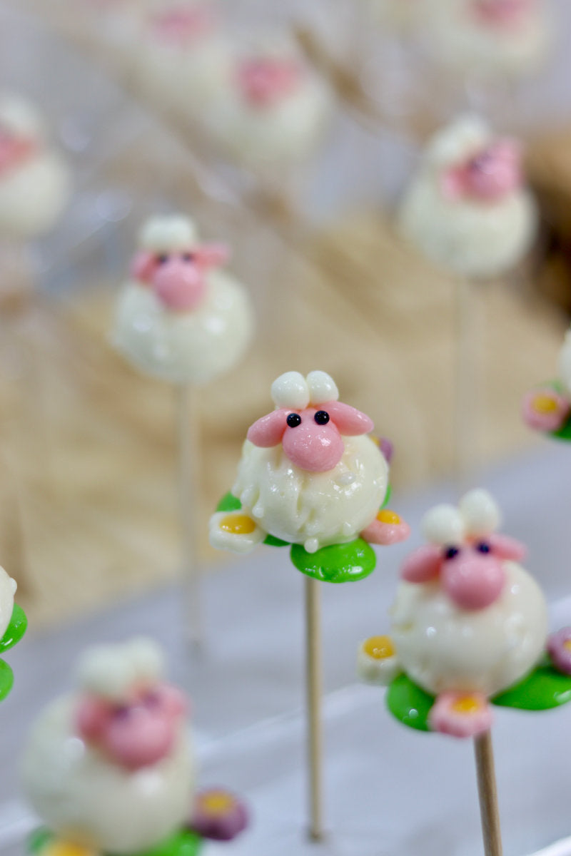 Sucette sculptée en forme de mouton à la banane et à la fraise dans une prairie fleurie multifruit. Dans notre atelier